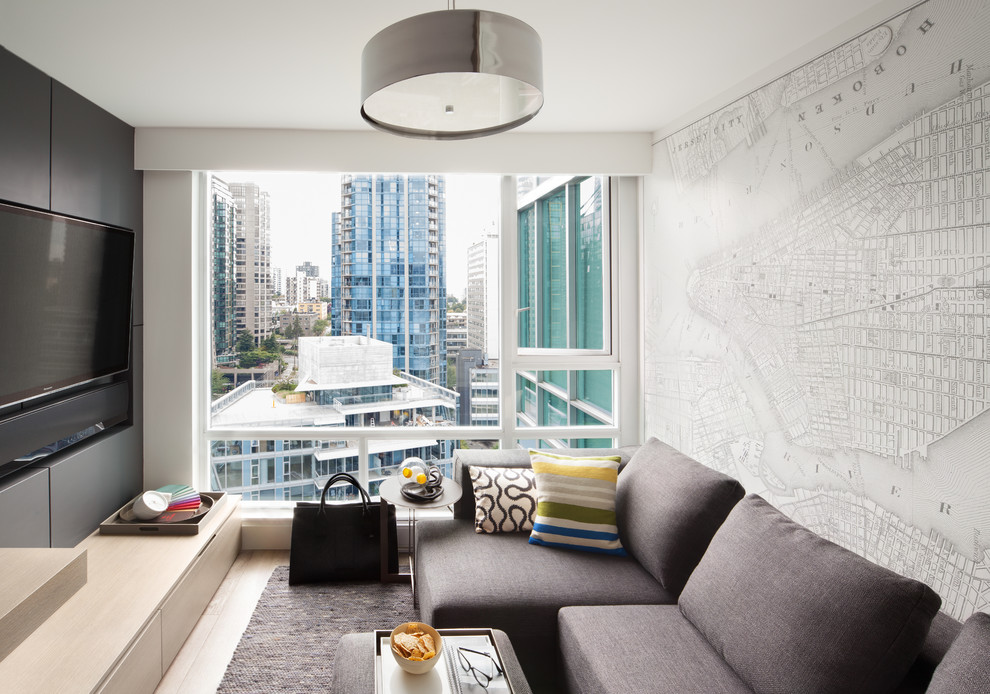 Inspiration for a small contemporary light wood floor family room remodel in Vancouver with a wall-mounted tv and white walls