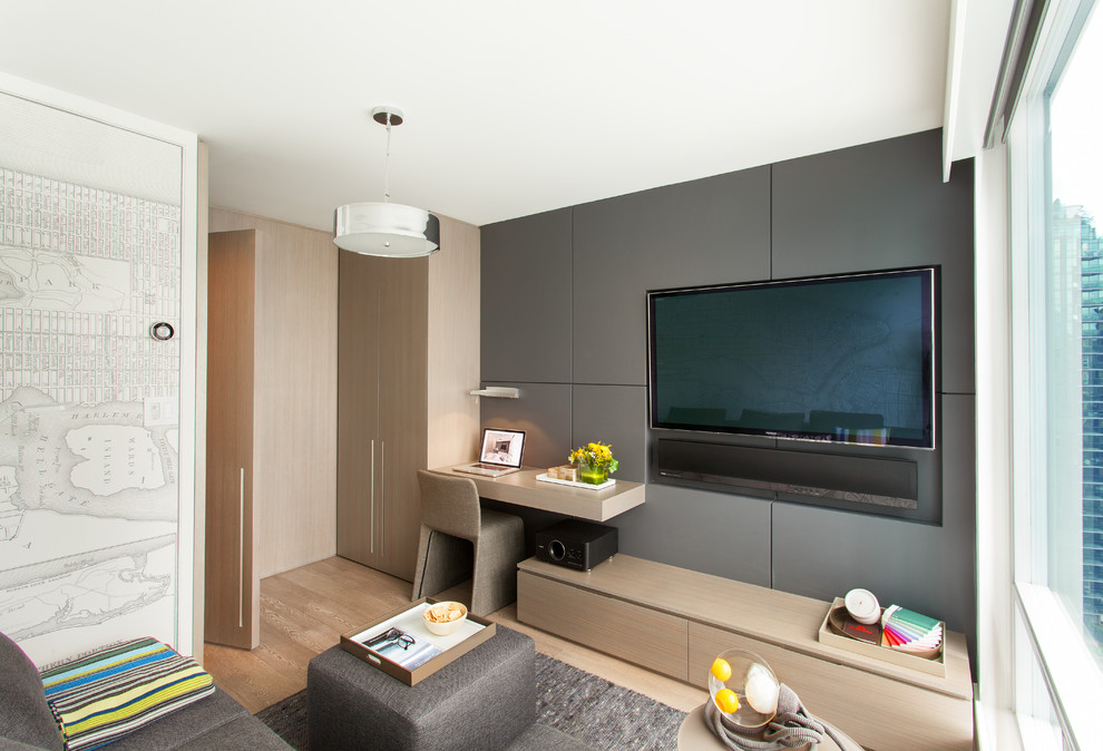 Diseño de sala de estar cerrada actual pequeña con paredes grises, pared multimedia y suelo de madera clara