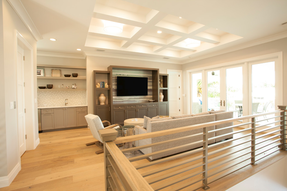 Idée de décoration pour une salle de séjour marine avec un mur beige, un téléviseur encastré et un sol beige.