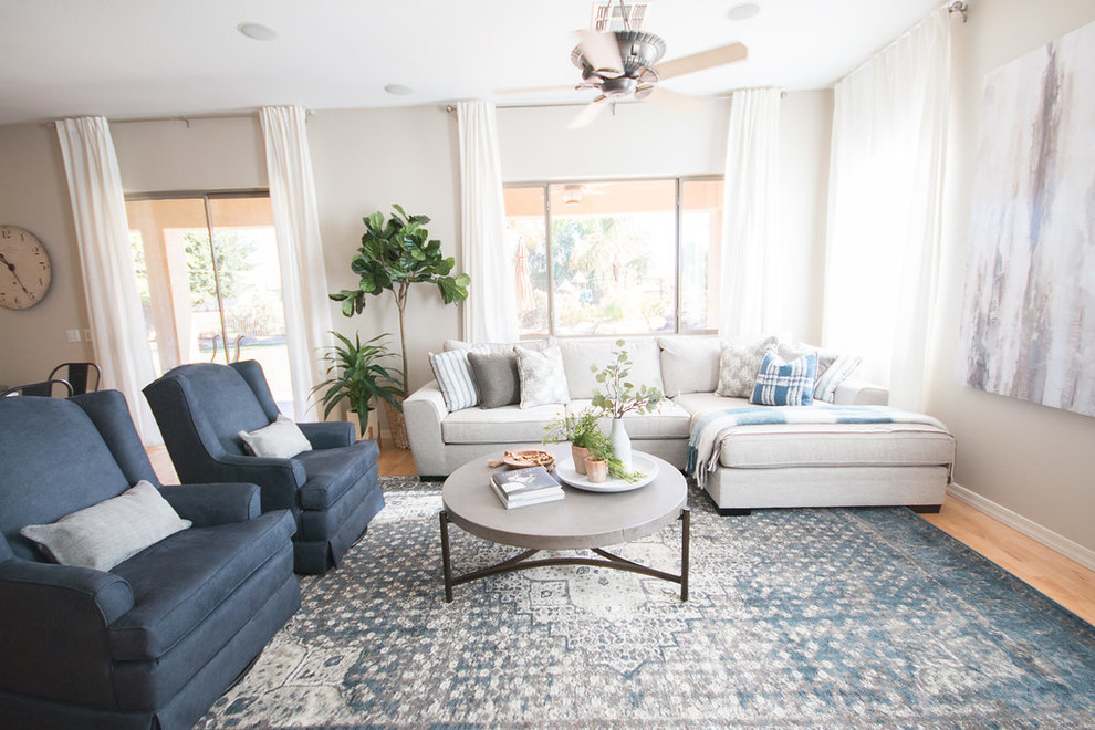 Mittelgroßes, Offenes Shabby-Style Wohnzimmer mit grauer Wandfarbe, hellem Holzboden, Kamin, Kaminumrandung aus Stein, TV-Wand und gelbem Boden in Phoenix