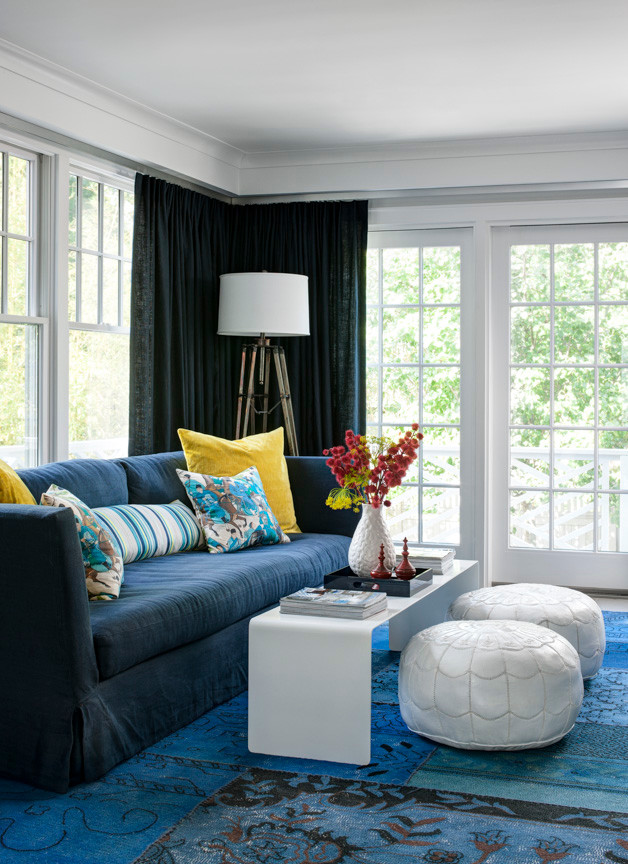 Immagine di un soggiorno stile marinaro aperto con libreria, pareti bianche, TV a parete e moquette