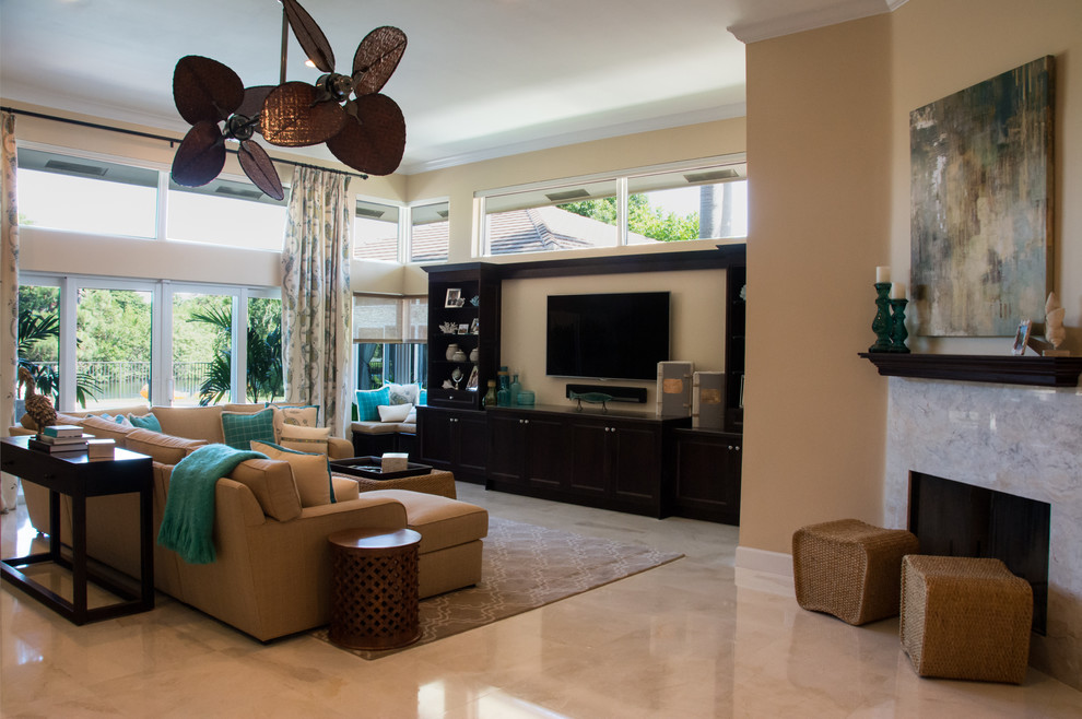 Großes, Offenes Maritimes Wohnzimmer mit beiger Wandfarbe, Marmorboden, Kamin, Kaminumrandung aus Stein und TV-Wand in Miami