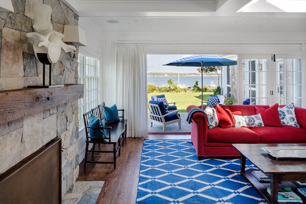 Medium sized beach style open plan games room in Boston with a home bar, white walls, medium hardwood flooring, a standard fireplace, a stone fireplace surround and a wall mounted tv.
