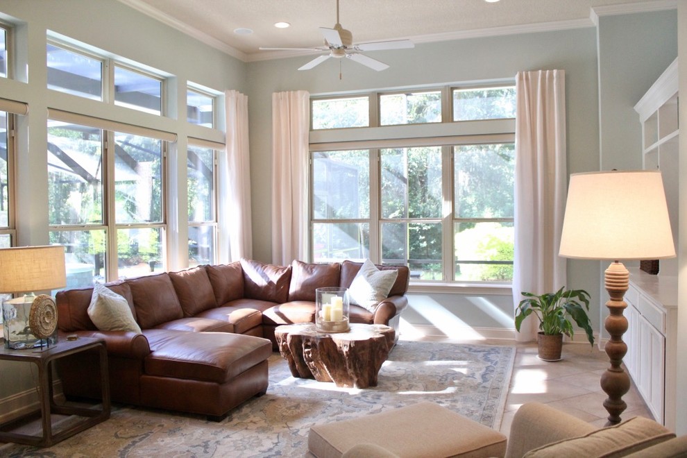 Exemple d'une grande salle de séjour tendance ouverte avec un mur vert, un sol en travertin, un téléviseur encastré et un sol beige.