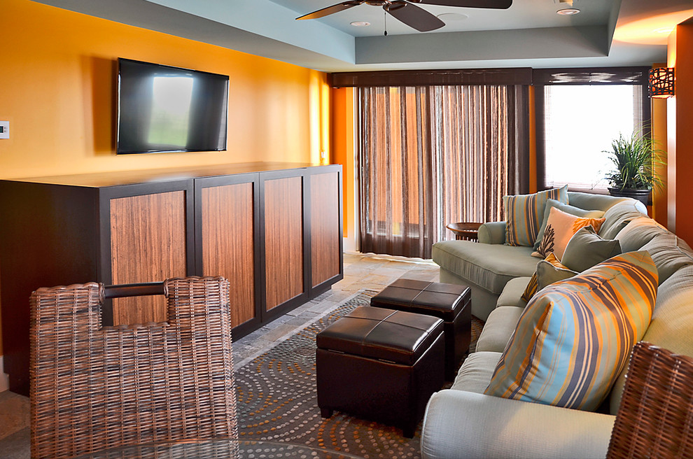 Bild på ett mycket stort maritimt allrum med öppen planlösning, med ett spelrum, orange väggar, ljust trägolv och en väggmonterad TV
