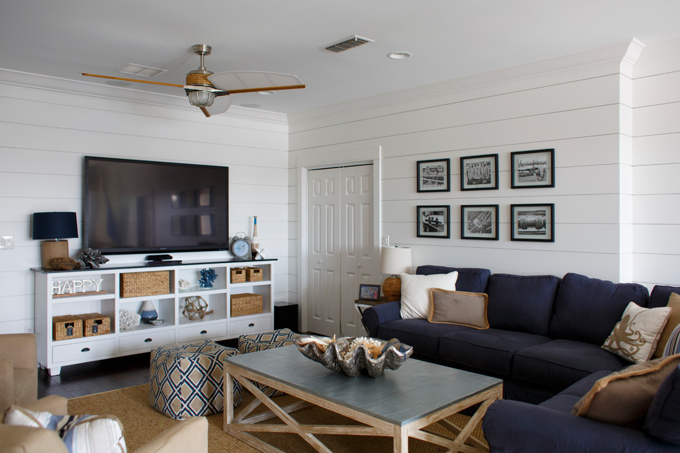 На фото: маленькая изолированная гостиная комната в морском стиле с белыми стенами, темным паркетным полом, отдельно стоящим телевизором и коричневым полом для на участке и в саду с