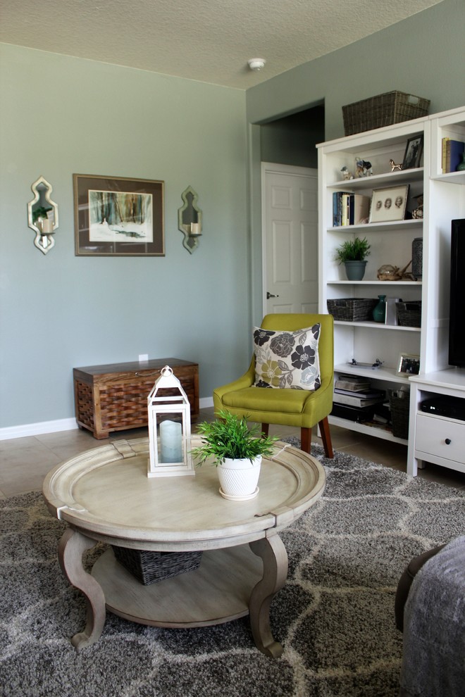 На фото: открытая гостиная комната среднего размера в морском стиле с зелеными стенами, отдельно стоящим телевизором и полом из керамогранита без камина с