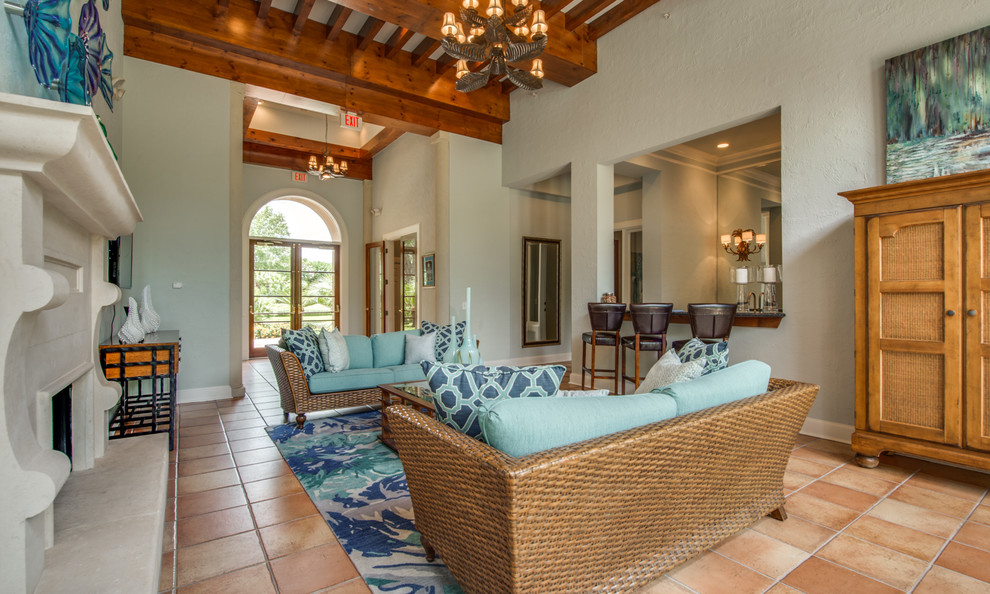 Foto di un soggiorno tropicale di medie dimensioni e chiuso con pareti blu, pavimento in terracotta, camino classico e pavimento arancione