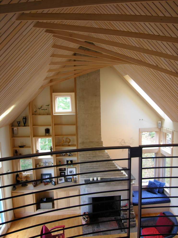 Aménagement d'une salle de séjour mansardée ou avec mezzanine contemporaine de taille moyenne avec un mur blanc, un sol en bois brun et une cheminée standard.
