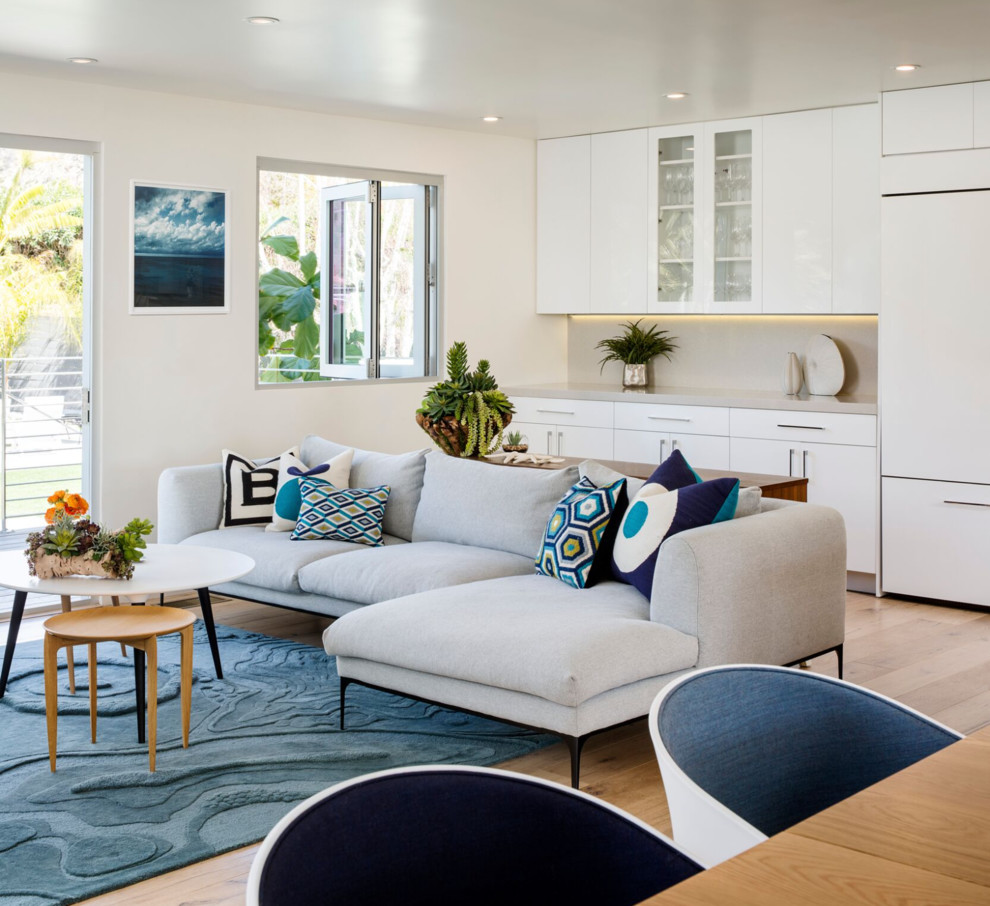 Esempio di un soggiorno minimalista di medie dimensioni e aperto con pareti bianche, parquet chiaro, TV a parete e pavimento beige