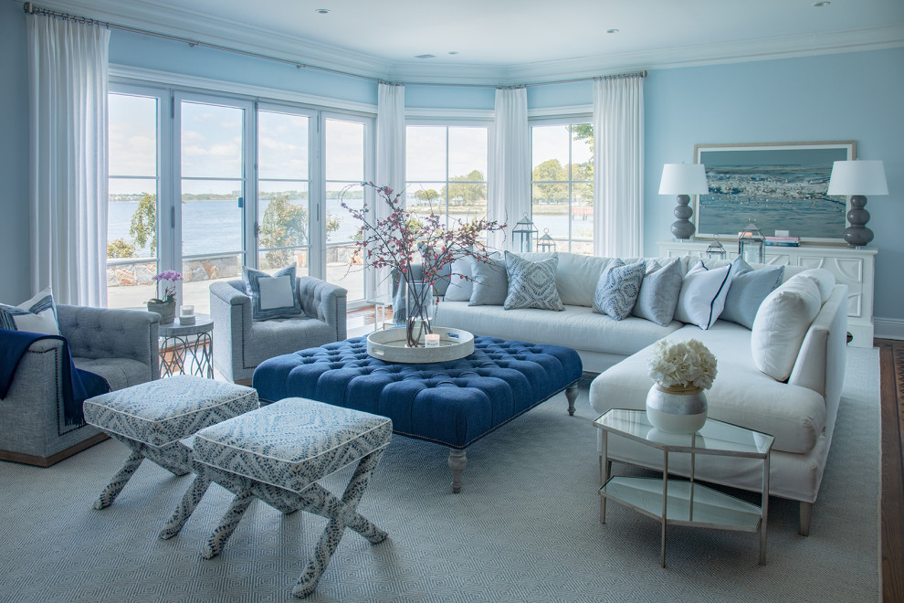 Imagen de sala de estar abierta marinera grande con paredes azules, suelo de madera oscura y suelo marrón