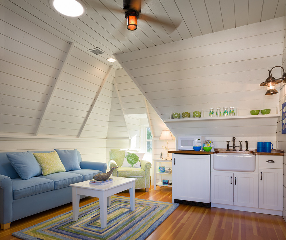 Ejemplo de sala de estar costera con paredes blancas y suelo de madera en tonos medios