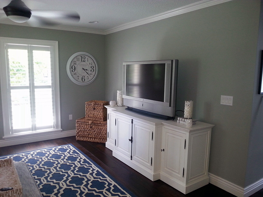 Пример оригинального дизайна: большая изолированная гостиная комната в стиле кантри с паркетным полом среднего тона, отдельно стоящим телевизором, коричневым полом и синими стенами без камина