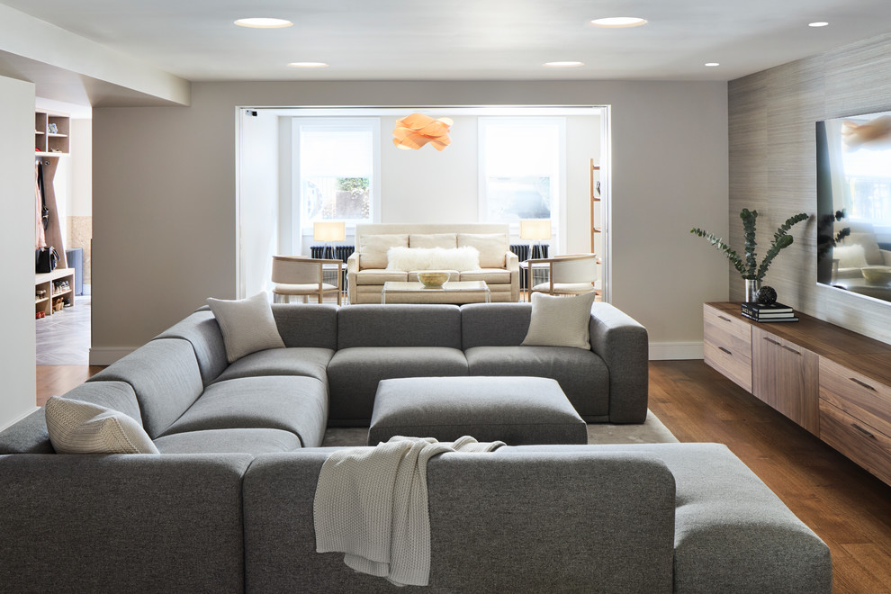 Foto de sala de estar abierta minimalista grande con paredes beige, suelo de madera en tonos medios y suelo marrón