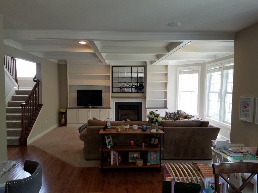 Ejemplo de sala de estar abierta tradicional de tamaño medio con paredes beige, moqueta, todas las chimeneas, marco de chimenea de madera, pared multimedia y suelo beige
