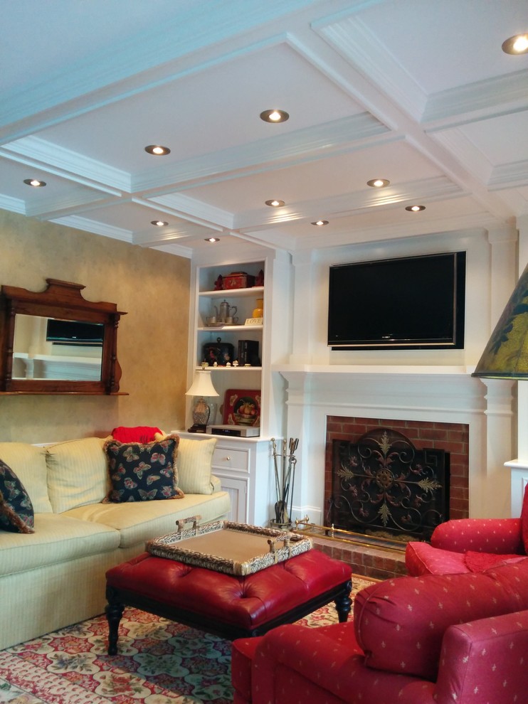 Ejemplo de sala de estar tradicional de tamaño medio con paredes beige, todas las chimeneas, marco de chimenea de ladrillo y televisor colgado en la pared
