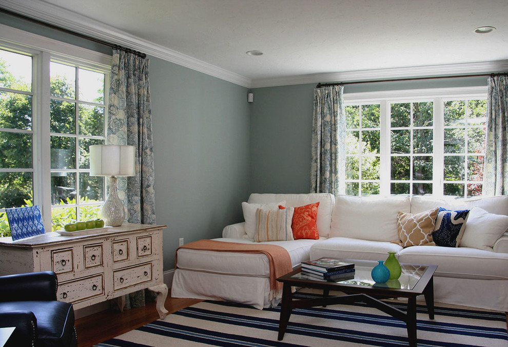 Modelo de sala de estar abierta clásica renovada grande sin chimenea y televisor con paredes azules y suelo de madera en tonos medios