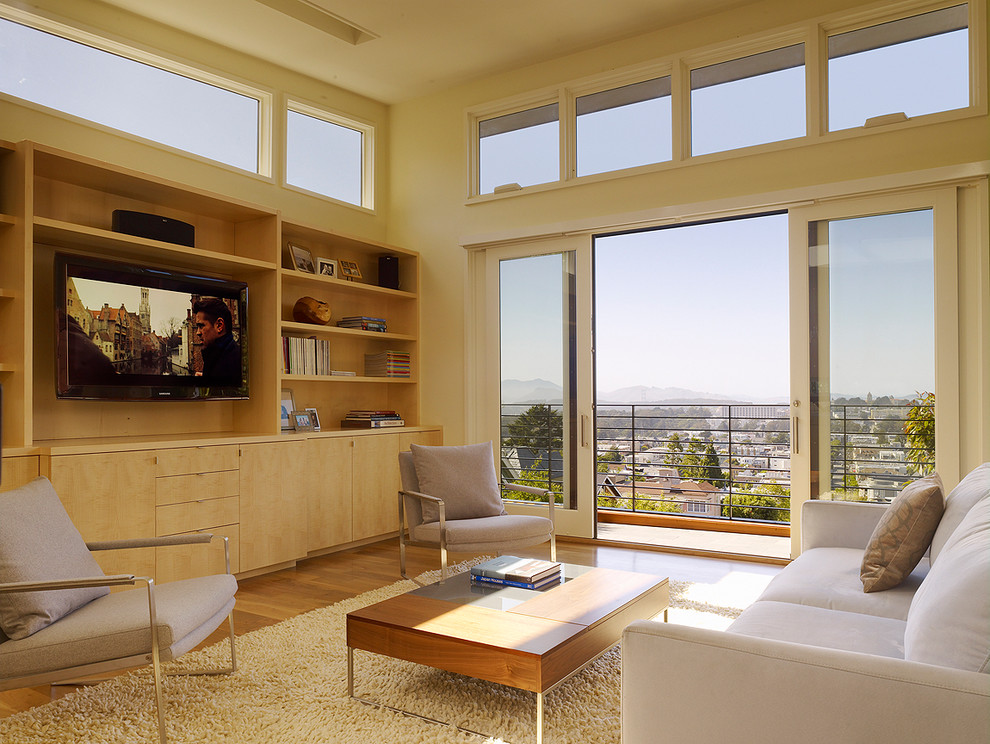 Cette image montre une salle de séjour design avec un mur beige, un sol en bois brun et un téléviseur encastré.