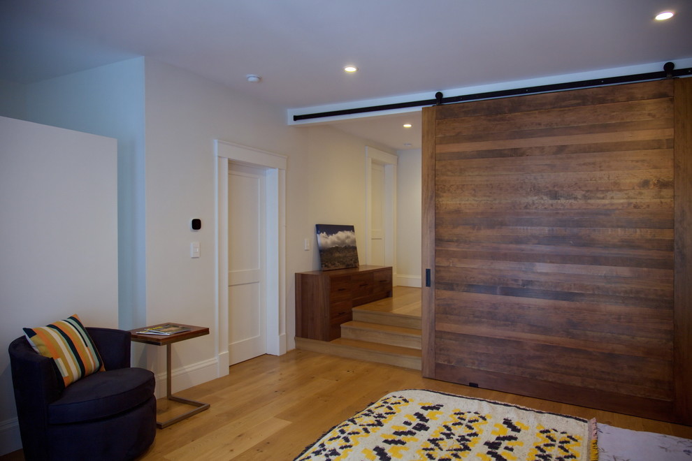 Imagen de sala de estar abierta clásica renovada grande sin chimenea con paredes blancas, suelo de madera clara y pared multimedia