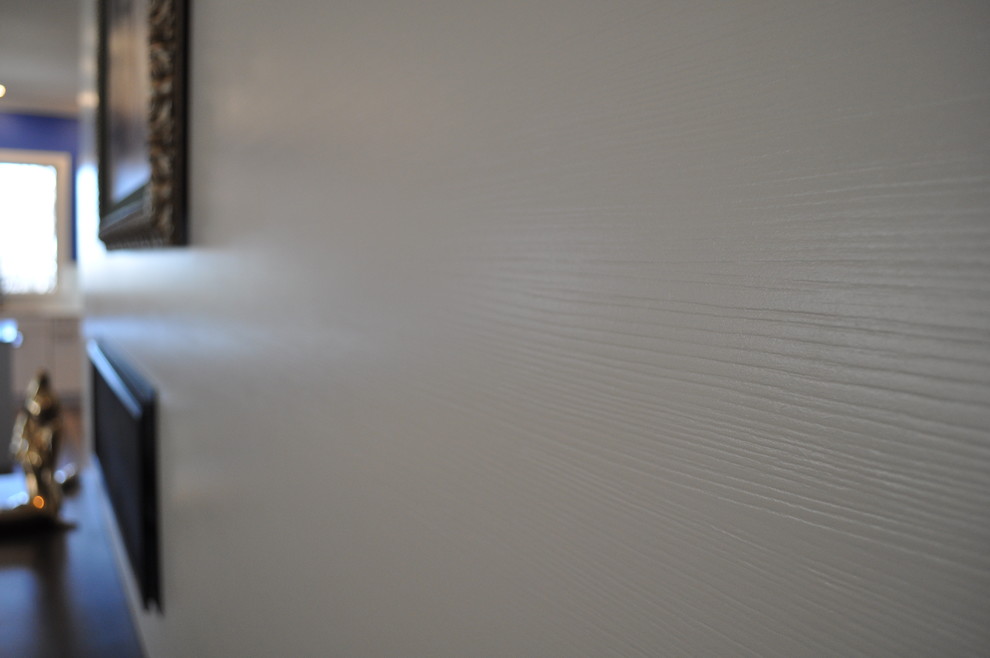 Immagine di un soggiorno minimal di medie dimensioni e aperto con pareti bianche, pavimento in legno massello medio, camino classico e cornice del camino piastrellata