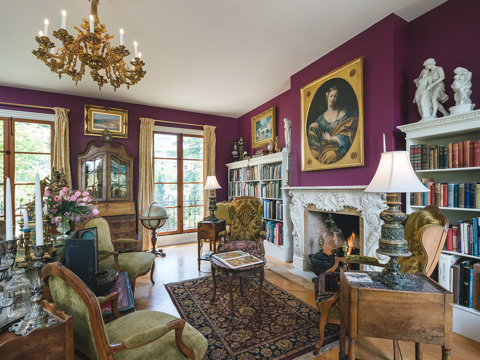 На фото: гостиная комната в викторианском стиле с фиолетовыми стенами, паркетным полом среднего тона, стандартным камином и коричневым полом