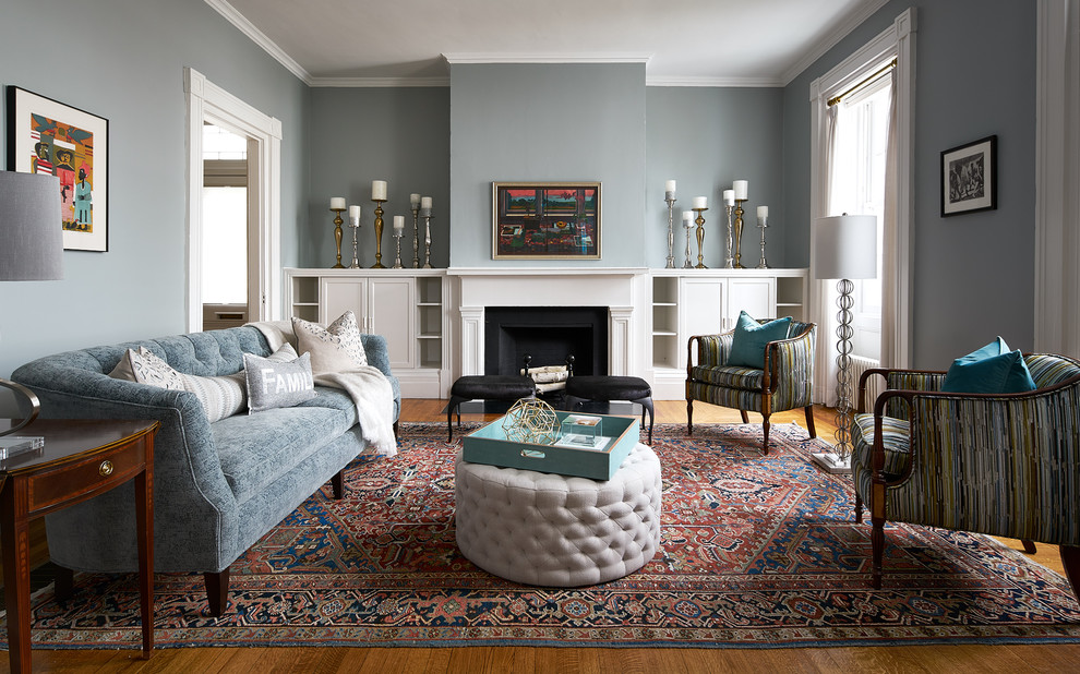 Esempio di un soggiorno classico chiuso con pareti grigie, pavimento in legno massello medio, camino classico e tappeto
