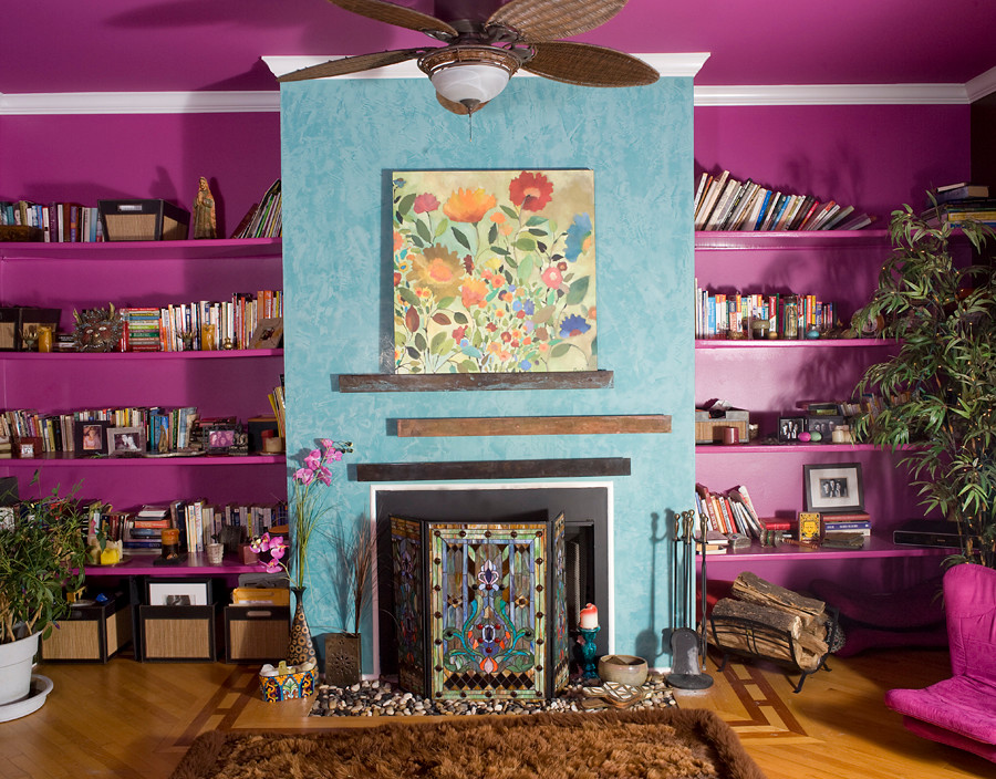 Exemple d'une salle de séjour éclectique de taille moyenne avec une bibliothèque ou un coin lecture, un mur violet, un sol en bois brun, une cheminée standard, un manteau de cheminée en métal et un sol marron.