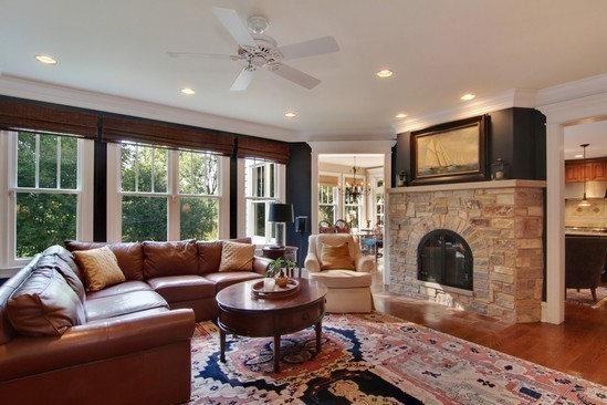 Example of a mid-sized classic open concept medium tone wood floor family room design in Chicago with blue walls, a two-sided fireplace, a stone fireplace and a wall-mounted tv