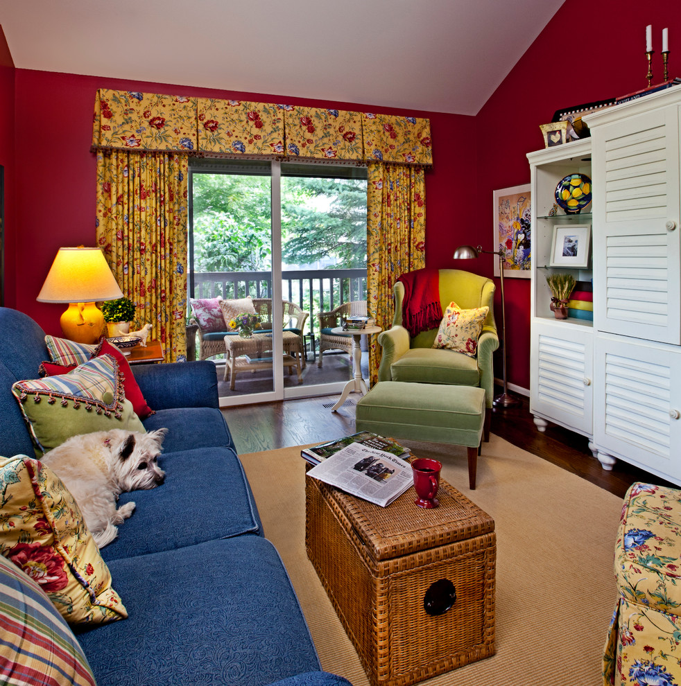 Aménagement d'une salle de séjour classique fermée et de taille moyenne avec un mur rouge, parquet foncé, aucune cheminée, un téléviseur dissimulé et un sol marron.