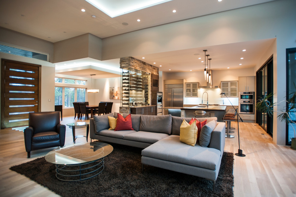 This is an example of a large contemporary open plan games room in Denver with grey walls, light hardwood flooring, no fireplace and beige floors.