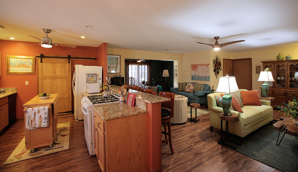 Mittelgroßes, Offenes Landhaus Wohnzimmer mit gelber Wandfarbe, Vinylboden, Kaminofen, Eck-TV, braunem Boden und Kaminumrandung aus Stein in Wichita
