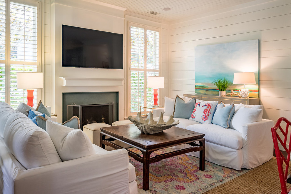 Свежая идея для дизайна: гостиная комната в морском стиле с белыми стенами, стандартным камином и телевизором на стене - отличное фото интерьера