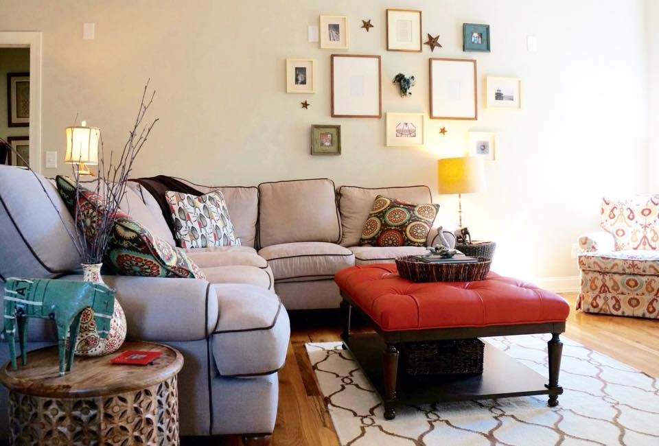 Imagen de sala de estar abierta ecléctica de tamaño medio con paredes grises, suelo de madera en tonos medios y televisor colgado en la pared