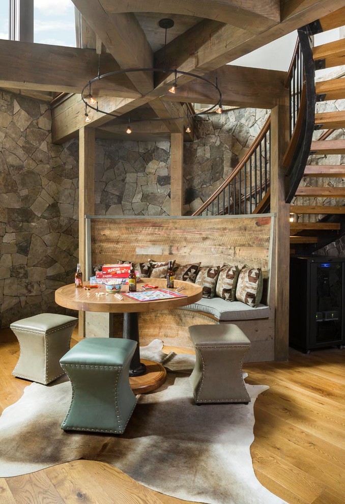 Ejemplo de sala de estar abierta rural de tamaño medio con paredes grises, suelo de madera en tonos medios, suelo marrón y vigas vistas
