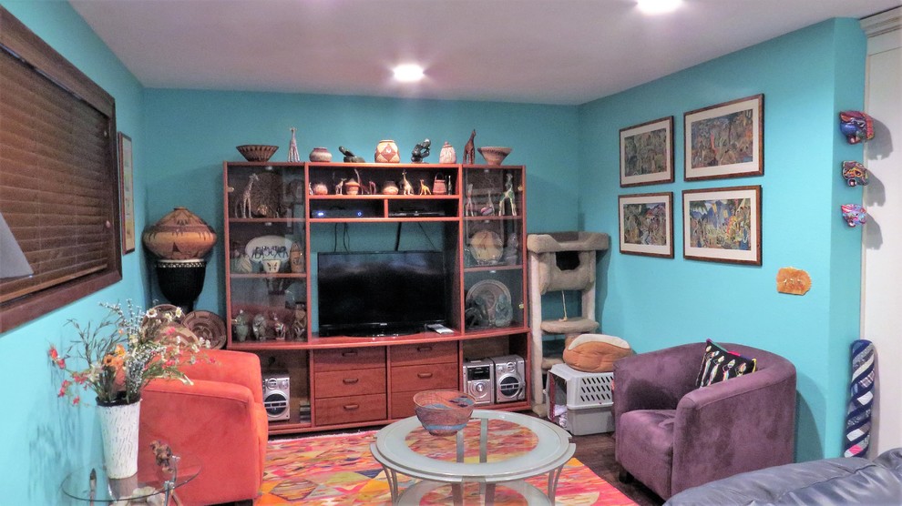 Esempio di un soggiorno eclettico di medie dimensioni e aperto con pareti blu, parquet scuro, stufa a legna, cornice del camino in mattoni e TV autoportante
