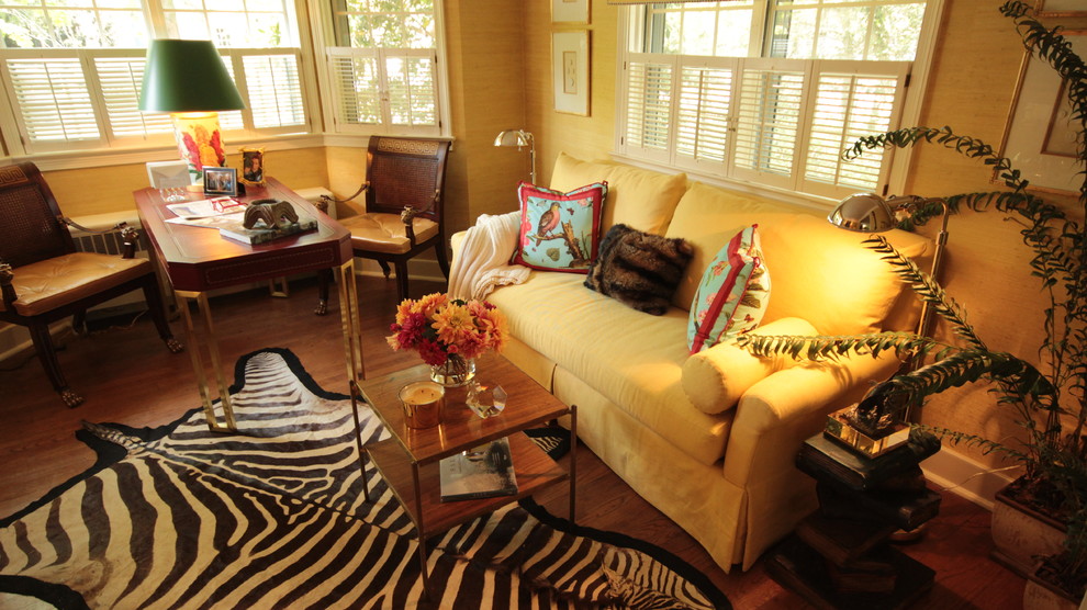 Immagine di un piccolo soggiorno tropicale chiuso con pareti gialle, pavimento in legno massello medio, nessun camino e TV autoportante