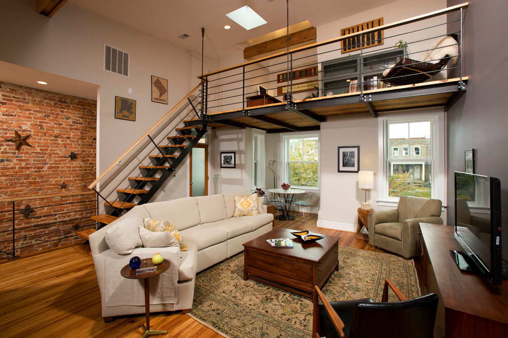 Modelo de sala de estar industrial grande sin chimenea con televisor independiente, paredes blancas y suelo de madera en tonos medios