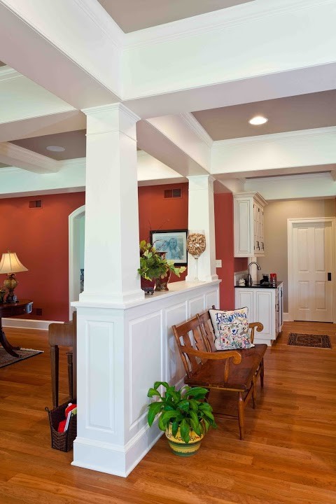 Ejemplo de sala de estar cerrada tradicional renovada de tamaño medio con paredes rojas, suelo de madera en tonos medios, todas las chimeneas, marco de chimenea de hormigón y televisor independiente