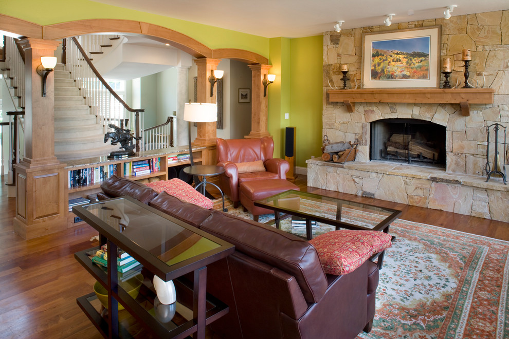 Family room - mid-sized eclectic enclosed medium tone wood floor family room idea in Boise with green walls, a standard fireplace and a stone fireplace
