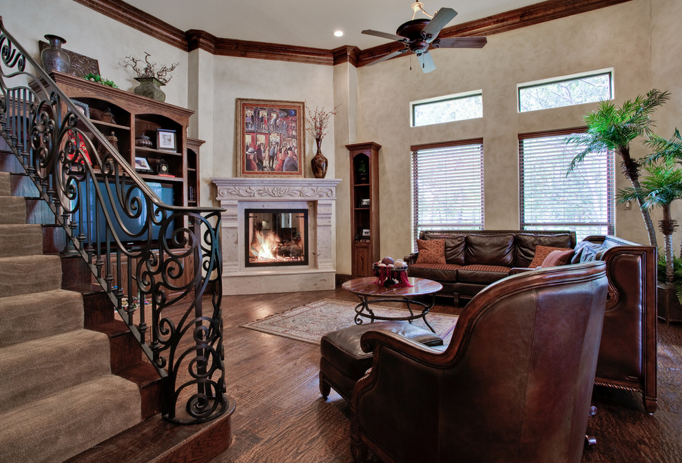 Example of a mid-sized classic open concept dark wood floor family room design in Dallas with beige walls, a standard fireplace, a stone fireplace and a wall-mounted tv