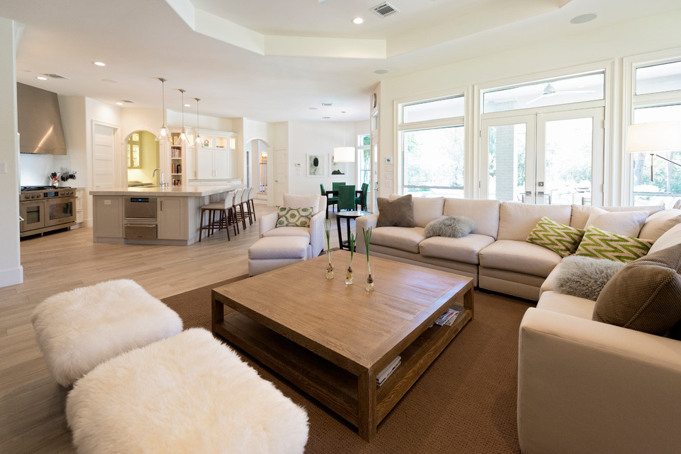 Großes, Fernseherloses Modernes Wohnzimmer mit weißer Wandfarbe, braunem Holzboden, Kamin, Kaminumrandung aus Beton und braunem Boden in Houston