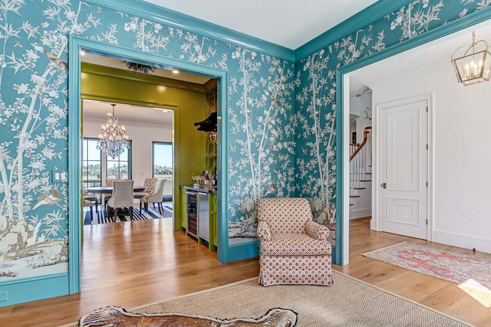Exemple d'une salle de séjour éclectique de taille moyenne et ouverte avec un bar de salon, un mur bleu, un sol en bois brun, une cheminée standard et un sol marron.