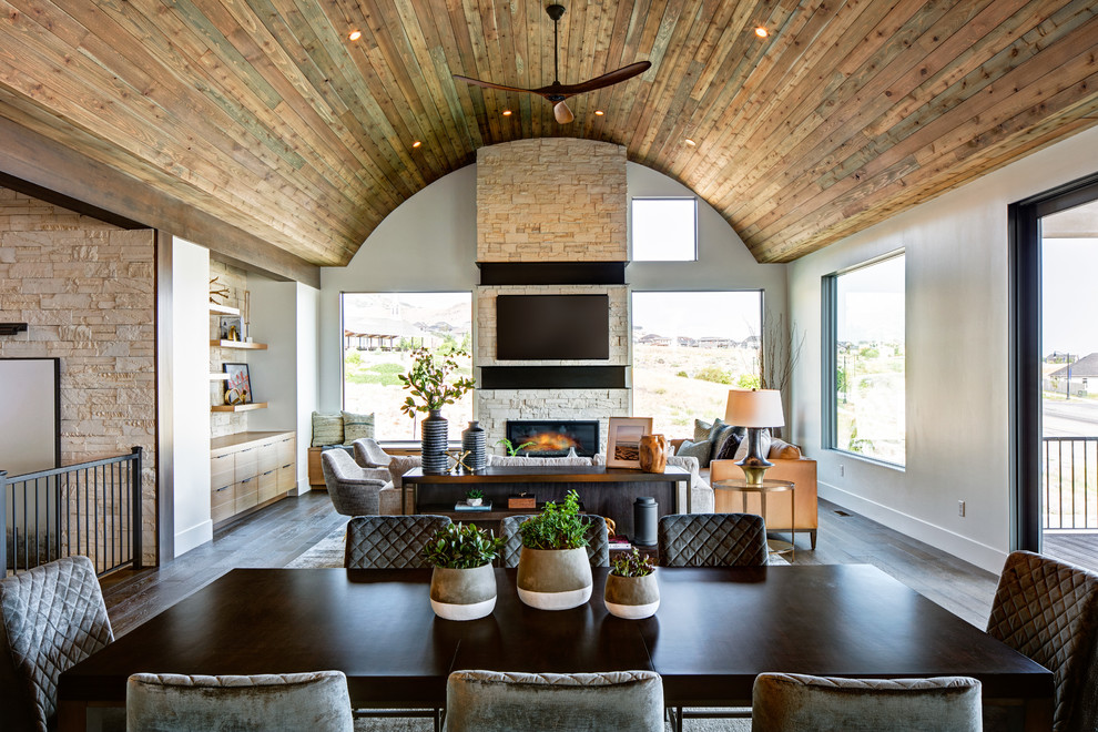 Inspiration for a large country open concept dark wood floor and brown floor family room remodel in Salt Lake City with white walls, a standard fireplace, a brick fireplace and a wall-mounted tv