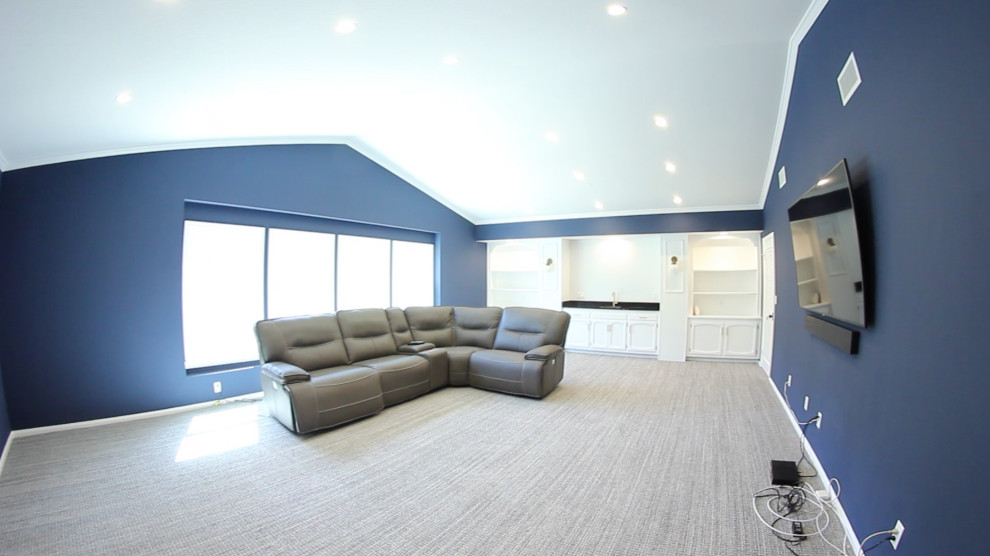 Ejemplo de sala de estar con barra de bar abierta actual grande sin chimenea con paredes azules, moqueta, televisor colgado en la pared y suelo gris