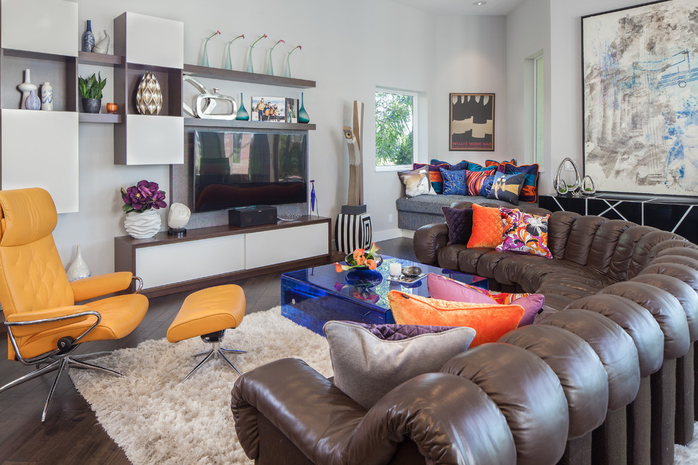 Example of an eclectic dark wood floor living room design in Miami with white walls and a wall-mounted tv