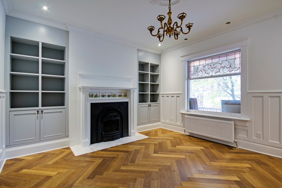 Medium sized traditional open plan games room in Toronto with white walls, medium hardwood flooring, a standard fireplace, a wooden fireplace surround, no tv and multi-coloured floors.