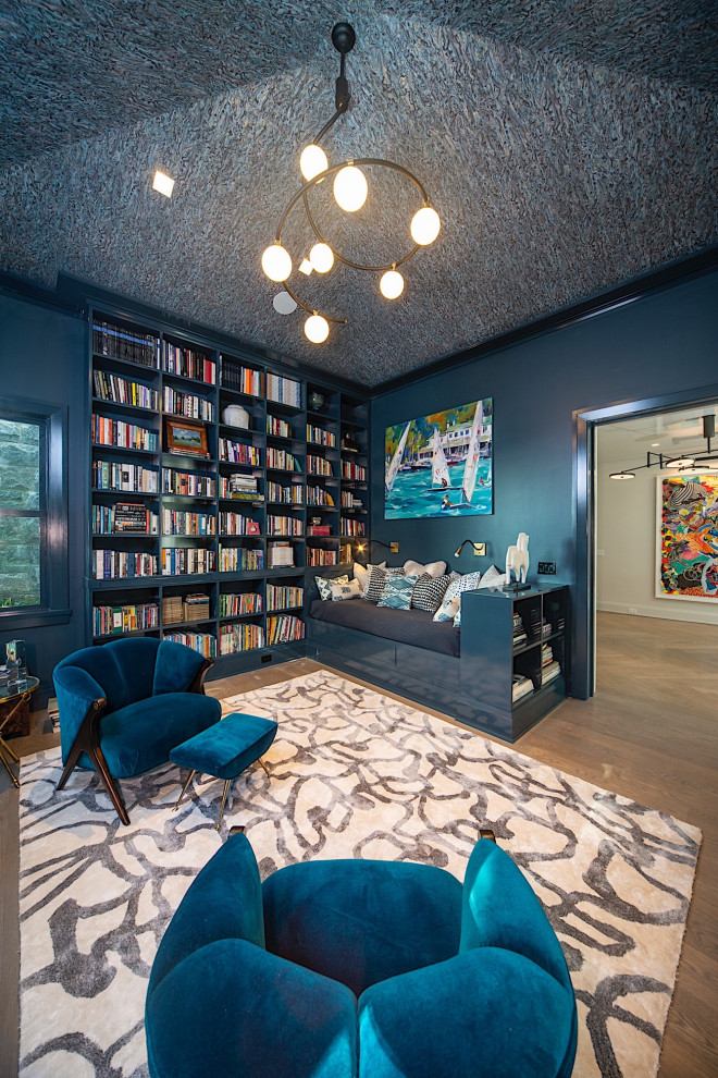 Esempio di un soggiorno minimal con libreria, pareti blu e pavimento in legno massello medio