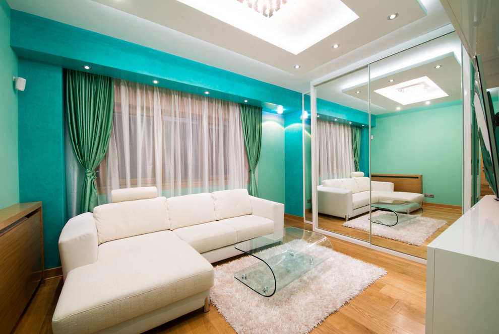 Kleines Eklektisches Wohnzimmer mit blauer Wandfarbe und hellem Holzboden in Orange County