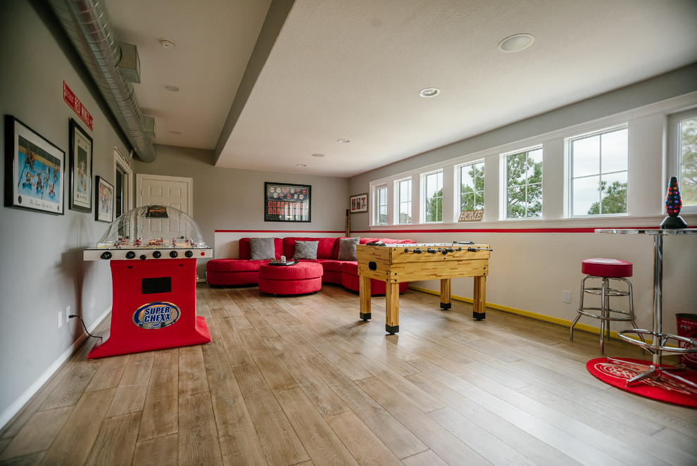 Imagen de sala de juegos en casa clásica extra grande con suelo de madera en tonos medios y paredes grises