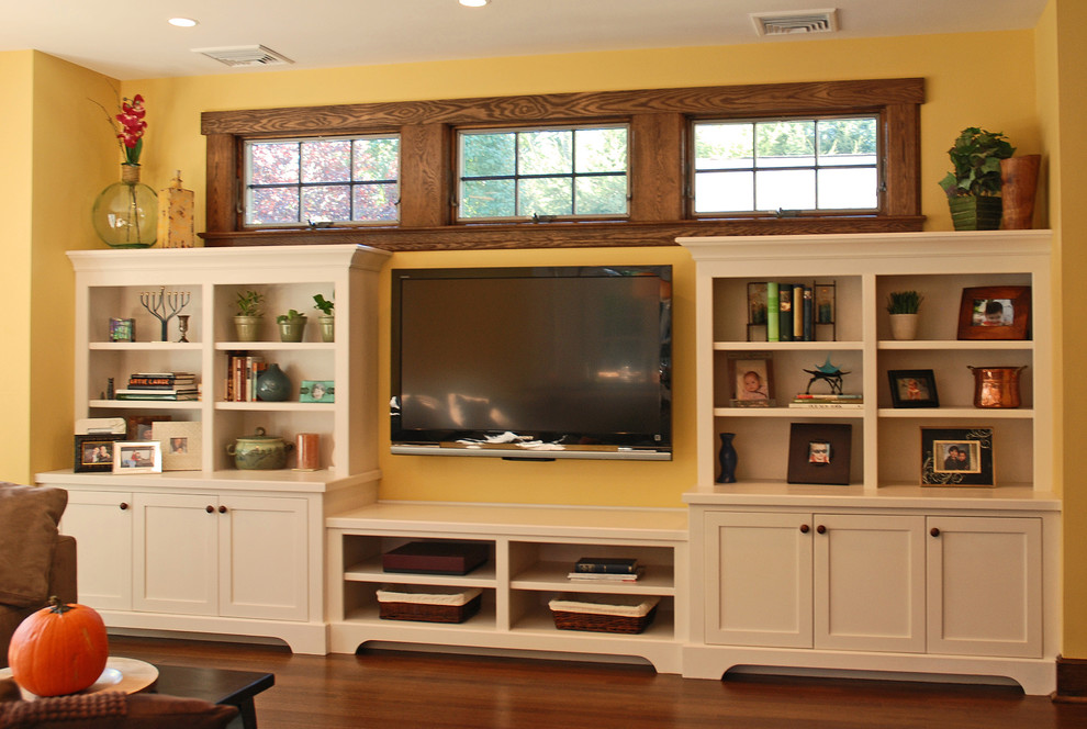 Источник вдохновения для домашнего уюта: большая открытая гостиная комната в стиле кантри с желтыми стенами, темным паркетным полом и телевизором на стене без камина